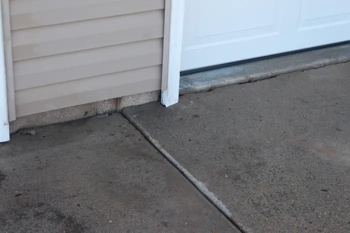 Gap between the garage floor and a settled driveway apron before polyfoam lifting
