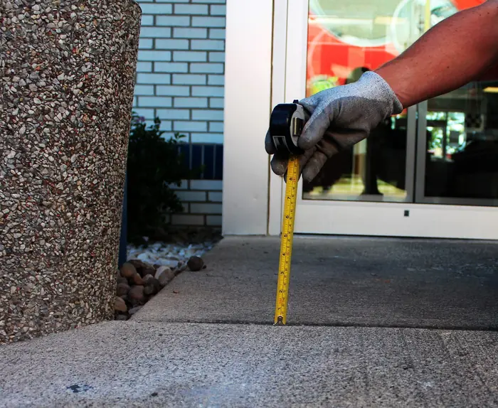 Concrete entryway slab settled at a commercial storefront before polyurethane foam lifting