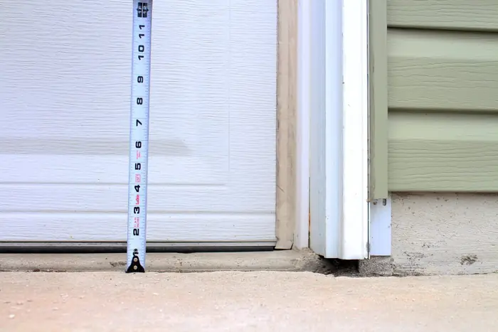 Concrete settled below the garage door threshold, measured with a tape, before polyfoam lifting