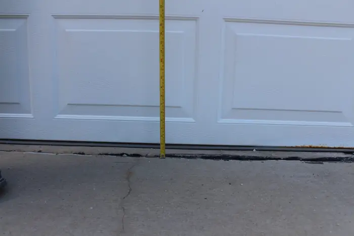 Gap opened under a garage door where the apron settled, measured with a tape, before polyfoam lifting