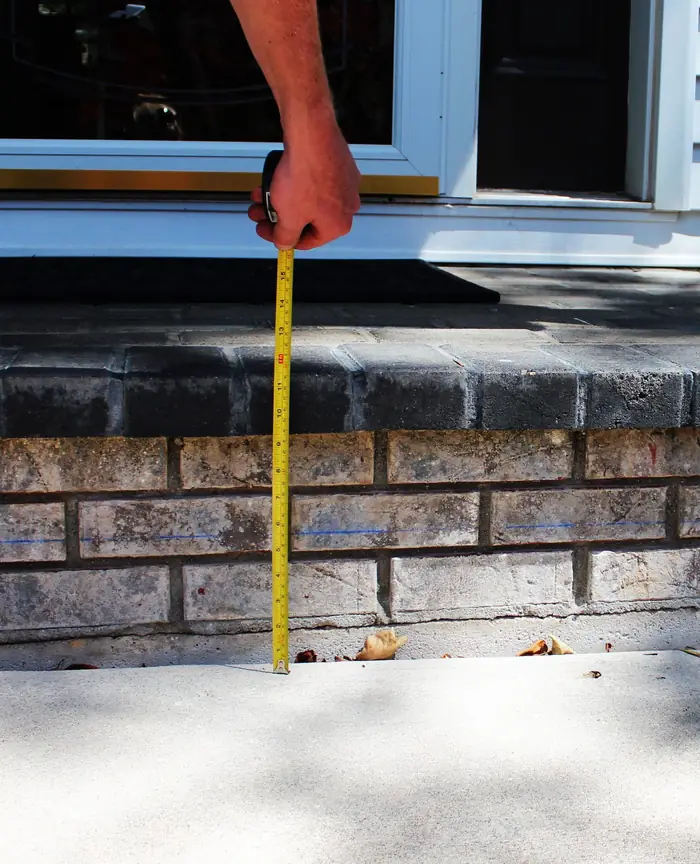 Front walkway settled below a brick porch step before polyurethane foam lifting